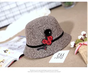 Detailed texture of a brown wool bucket hat with red flower embroidery and velvet ribbon