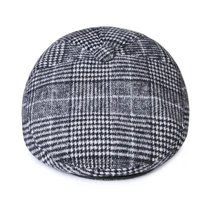 Close-up of winter men's houndstooth newsboy cap with wool texture and top button