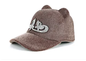 Detailed view of a brown faux mink fur equestrian hat featuring cat ears and rhinestones