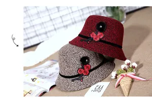 Detail of wool cloche hats with plum blossom embroidery and pompom decoration