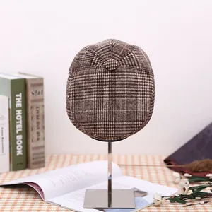 Detail of vintage brown plaid flat cap made of warm fleece wool with retro textures