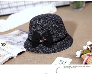 Detail of wool knit bucket hat with velvet bow and floral embroidery decoration
