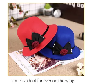 Detail of wool felt dome hats with large black bows and fabric roses in red and royal blue