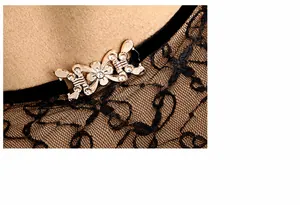 Close-up of golden butterfly buckle with rhinestones on lace felt hat detail