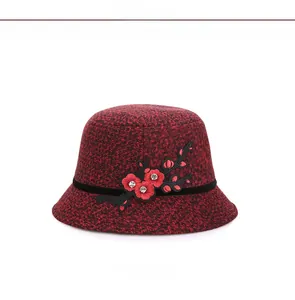 Detail of red wool bucket hat featuring plum blossom embroidery and rhinestone accents