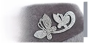 Detail view of sparkly rhinestone butterfly decoration on soft grey plush equestrian hat