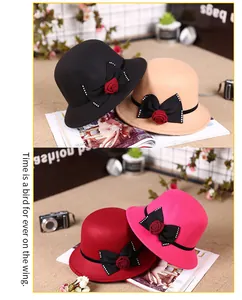 Detail of four colorful wool cloche hats with decorative ribbon and rose on a magazine