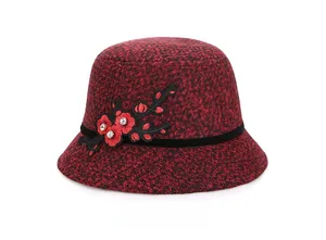Detail of red and black wool felt bucket hat with plum blossom embroidery and sequins