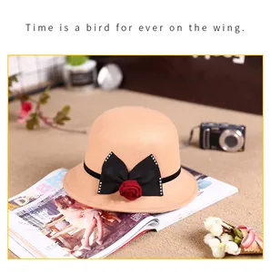 Detail of wool cloche hat featuring a black bow with a red 3D rose and sequins