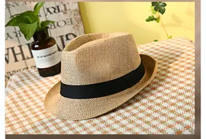 Dettaglio ravvicinato del cappello di paglia intrecciata traspirante con nastro nero