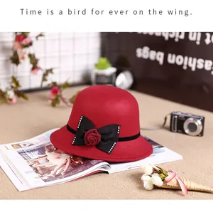 Detail of red wool felt cloche hat with a black bow and silk rose decoration