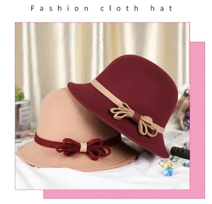 Elegant cloche hat detail showing burgundy and beige felt textures with bow ribbons