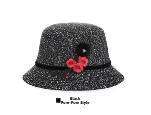 Detailed close-up of wool cloche hat with red floral embroidery and black fur ball accessory