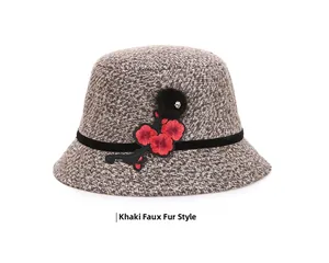Detail of khaki tweed bucket hat with floral embroidery and elegant black pom-pom