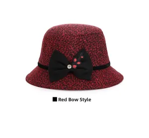 Detail of red wool bucket hat featuring a black bow with rhinestones and embroidery
