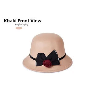 Détail d'un chapeau en laine kaki avec nœud noir et décoration de rose rouge