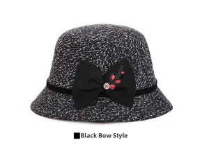 Detail of tweed bucket hat with large black bow, red leaf embroidery and crystal accent