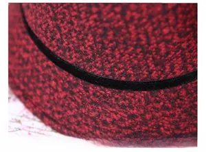 Detail of red and black tweed fabric with elegant black velvet ribbon on winter hat