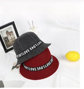 Close-up of wool bucket hats in grey and red with LOVE letter ribbon detail