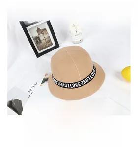 Close-up of camel wool cloche hat featuring black decorative tape with LOVE lettering
