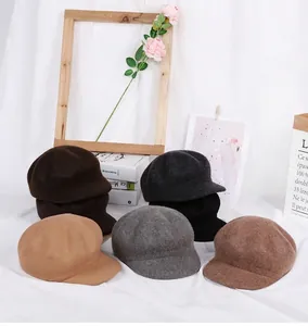 Detail view of retro wool newsboy caps in six classic autumn colors on a lifestyle background