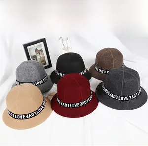 Detail view of colorful wool felt bucket hats with decorative LOVE lettered ribbon trim