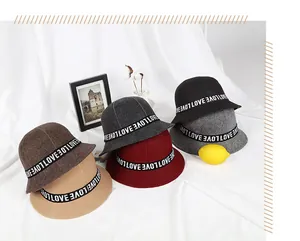 Flat lay of cloche fisherman hats in six colors with LOVE decorative ribbon detail