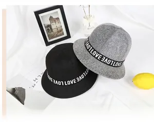 Fashionable black and grey felt bucket hats with LOVE letter ribbon on fabric background