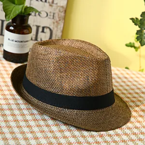 Cappello fedora classico in paglia marrone con nastro nero su tovaglia a quadretti