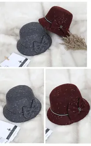 Detail of wool cloche hats with decorative bows and rhinestones in grey and burgundy