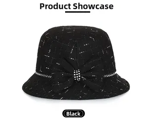 Detail of elegant black tweed bucket hat featuring a large bow and white pearl embellishment