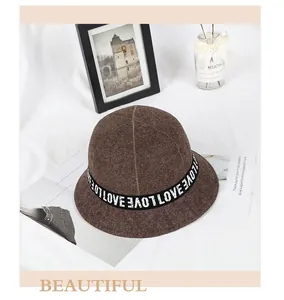 Detail of dark brown wool bucket hat showing stylish LOVE letter ribbon trim