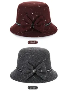 Detail of tweed bucket hats in red and grey with decorative bow and rhinestone accents