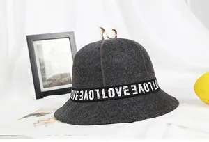Close-up of a dark grey wool fisherman bucket hat with white LOVE lettered ribbon