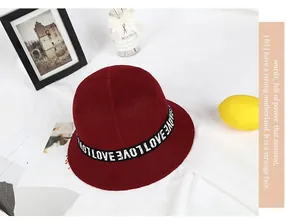 Close-up of wine red wool bucket hat with LOVE ribbon strap on minimalist background