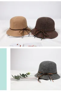 Close-up of wool felt bucket hats in khaki, dark brown and grey with leather bow detail