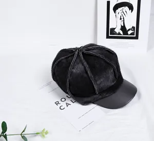 Detail of winter newsboy hat featuring plush faux fur body and black leather brim contrast