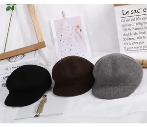 Three wool newsboy caps in black, brown, and grey shown with minimalist decor