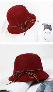 Detail view of burgundy wool cloche hat with stylish brown leather bow decoration
