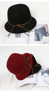 Detail of wool cloche hats in black and wine red with leather bow band and texture