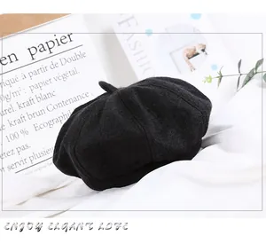 Classic black wool beret with small top detail on elegant French style background