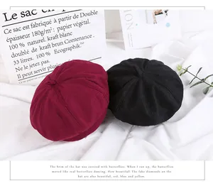 Detail view of stylish wine red and black wool felt beret hats in a minimalist setting