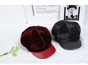 Detail of dark red and black newsboy caps featuring plush texture and leather brim