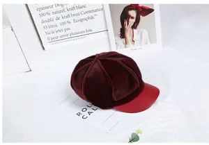 Detailed view of burgundy newsboy hat featuring premium faux fur texture and leather brim
