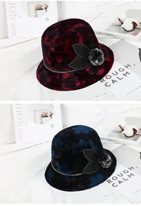 Detailed close-up of velvet floral bucket hats in wine red and navy blue with fur ball decor