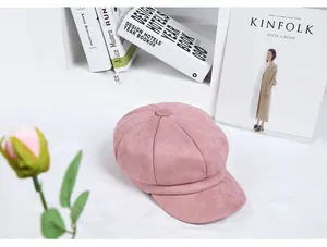 Detail of soft pink octagonal newsboy hat on a minimalist aesthetic desk with books