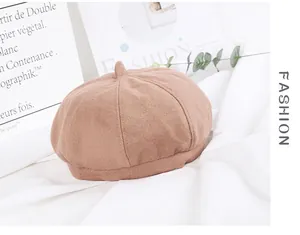 Detail of a brown wool felt beret with classic stitched panels and top stem decoration