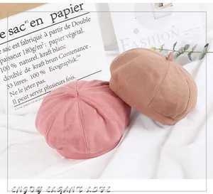 Close-up of wool beret hats in pink and beige colors showing pumpkin panel stitching