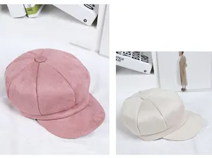 Detail of suede newsboy caps in pink and off-white with soft plush texture