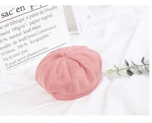Pink woolen beret for women on soft white fabric with minimalist decor elements
